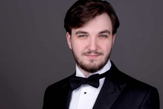 Ottawa Headshot Photographer a young man classical music singer headshot on grey background wearing bow tie and tuxedo