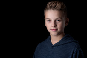 Young boy actor headshot on a black background