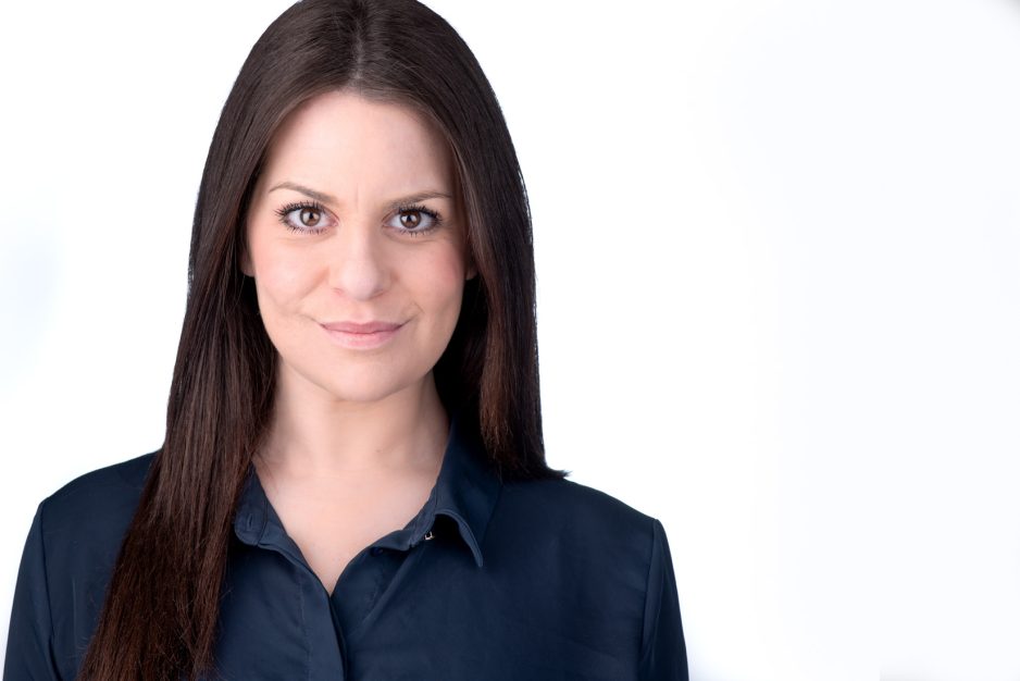 Young woman headshot in a dark top against white background on headshot photo web site
