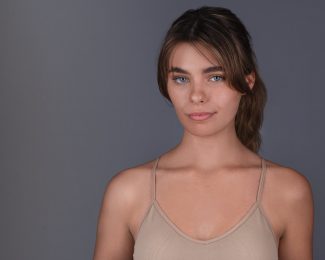 Young woman with her hair tied back and a pouty, sultry look
