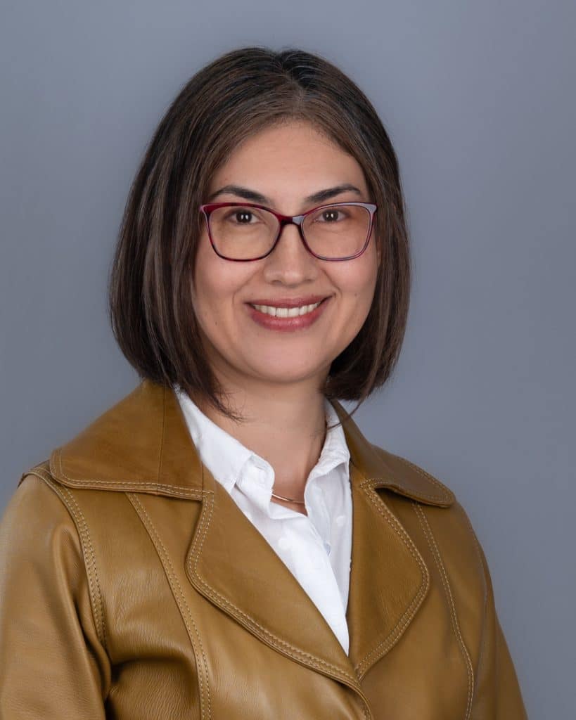 Headshot session Ottawa woman with short hair to chin with brown leather jacket and red glasses