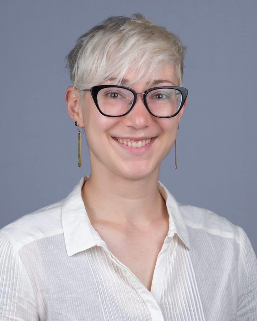 Team headshot session Ottawa convention young woman platinum hair stylish glasses long earrings grey background